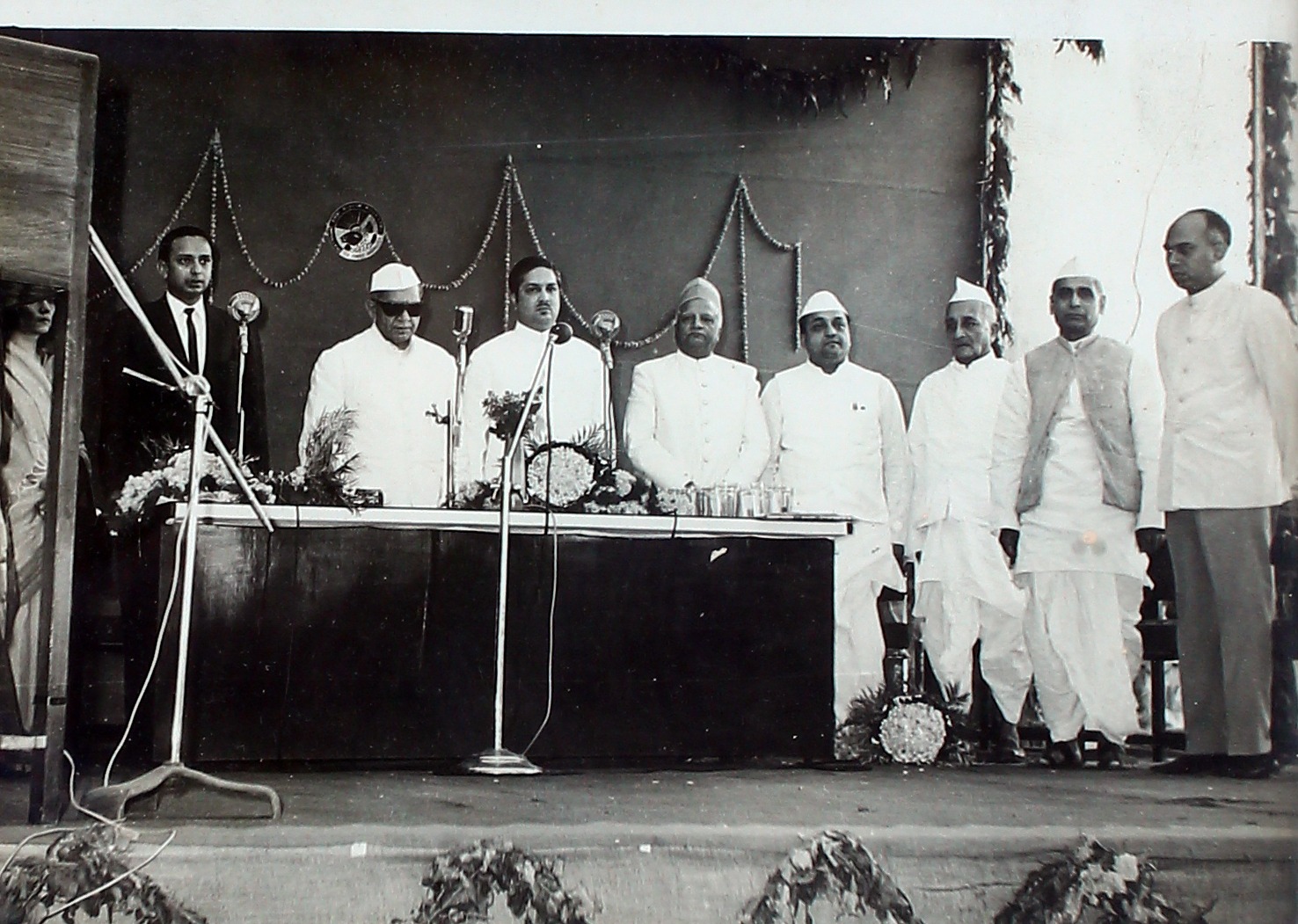 Guests assembled on a dais at a company function.